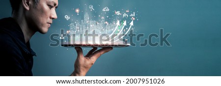 A man using a tablet analyzing sales data and economic growth graph chart. Business strategy. Abstract icon. Digital marketing. The concept is investing in cities using online technology.