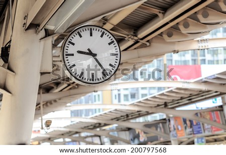 Public clock In a railway station with roof perspective roof station train and build background blur sunlight in the morning ,pass time ,Bangkok