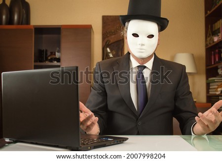 businessman disguised with a mask and hat telecommuting from home due to covid restrictions