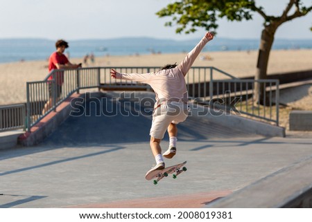 young man on skateboard jumping in skatepark