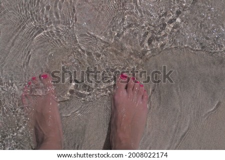 The legs of a young girl on the beach close up.