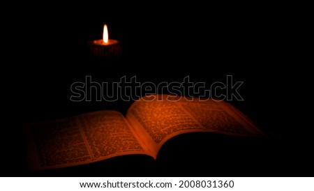 Ancient Castle. The Ancient Scriptures Lying On The Table. Glow From Burning Candle Illuminates Old Book. Royalty-Free Stock Photo #2008031360