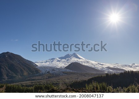Beautiful landscape of a snowy volcano and the sun of the afternoon making a backlighting effect