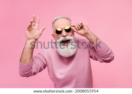Photo of funky cool mature man dressed pullover arm dark glasses smiling waving arm hello isolated pink color background