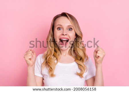 Photo of cheerful young positive woman raise fists scream win celebrate isolated on pastel pink color background