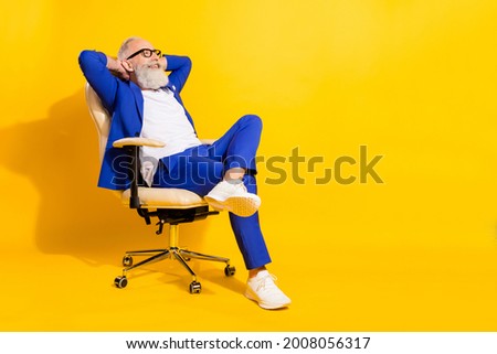 Full size photo of happy smiling businessman sit chair relaxing having break from work isolated on yellow color background