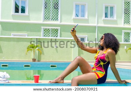 beautiful lady taking picture by the pool