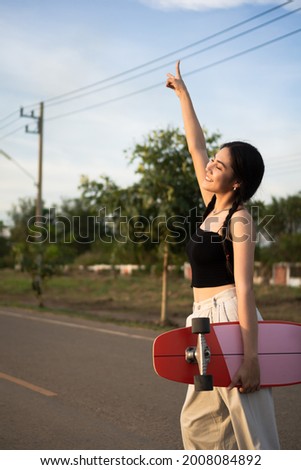 beautiful girl with pink skateboard on the road
