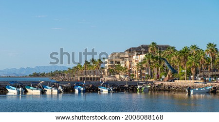 Pangas or boats on the bay of Loreto with architecture and palm trees on the Malecon in a sunny morning of summer, the Baja peninsula in the state of Baja California Sur. MEXICO Royalty-Free Stock Photo #2008088168