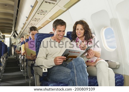 Passengers reading book on airplane Royalty-Free Stock Photo #200809109