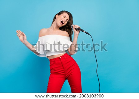 Portrait of attractive cheerful careless dreamy girl singing hit having fun rest isolated over vibrant blue color background Royalty-Free Stock Photo #2008103900