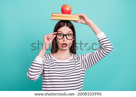 Photo of surprised genius lady hold pile book head have inspiring idea wear striped shirt isolated on teal background