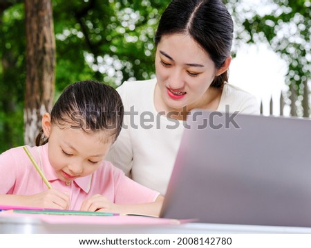 Young mothers help their children with their homework high quality photo
