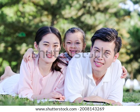 Happy family of three on the park grass high quality photo