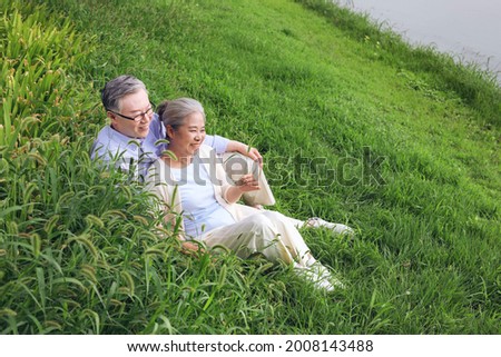Happy old couple watching the scenery by the lake high quality photo