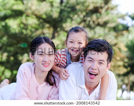 Happy family of three on the park grass high quality photo