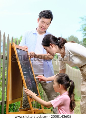 Happy family of three painting in the park high quality photo