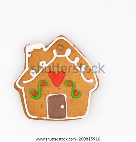 gingerbread house with a red heart and the pipe decorated with icing on white background