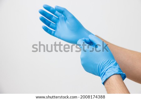 Man wearing blue latex nitrile groves (select focus) Royalty-Free Stock Photo #2008174388