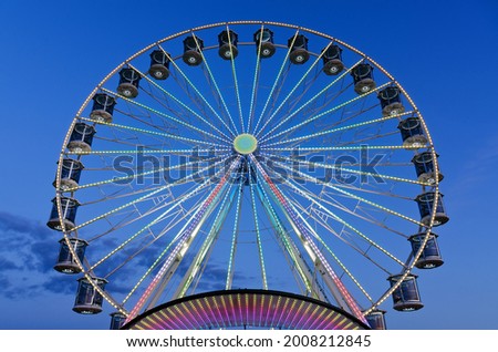 High Ferris Wheel against blue sky in our summer vacation at Adriatic seaside. Amusement park ride. Holidays concept.