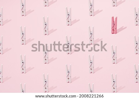 Pink and white wooden clip on a pink background. Minimal design and pattern.