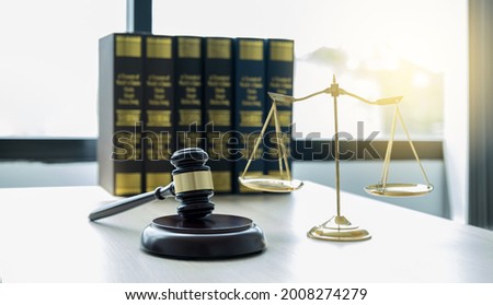 Gavel hammer, justice scale, and law textbook on table in lawyer office for providing legal consult business dispute service.