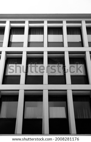 Reworked photo of multistory building. Windows of concrete block. Modular wall construction. Abstract modern architecture background in minimal style. Geometric background with rectangular pattern.