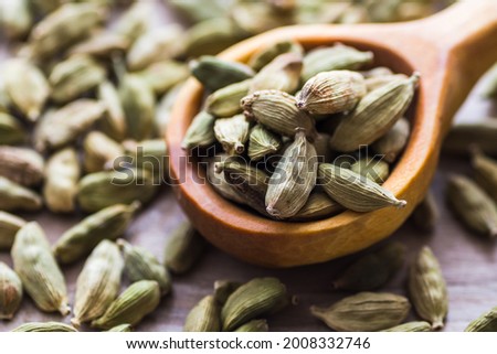Green cardamom in a wooden scoop, aromatic spice used in the kitchen, providing many health benefits. Royalty-Free Stock Photo #2008332746