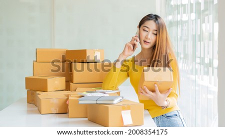 Starting an Asian Entrepreneur Small business, SME independent, young woman working at home with boxes on the floor and laptop online, marketing, packaging, transportation, SME, e-commerce concept	