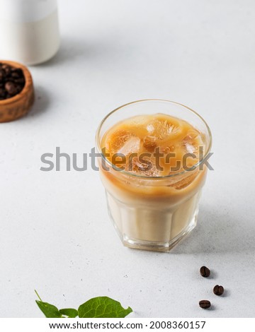 Cold coffee with ice and cream on a white background. Homemade cold latte. 