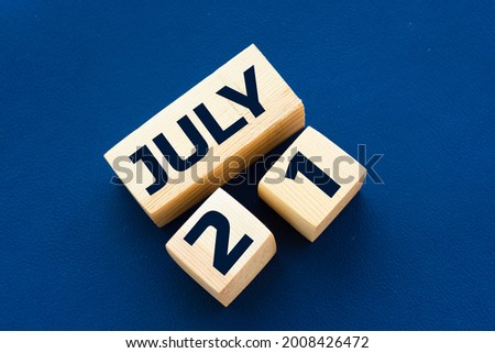 July 21st. Day 21 of month, wooden color calendar on blue background. Summer time.