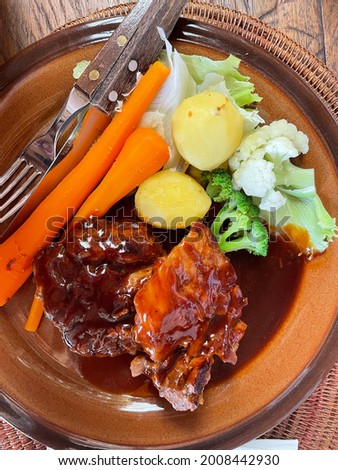 Picture of delicious home steak with sauce, carrots, potatoes, and broccoli