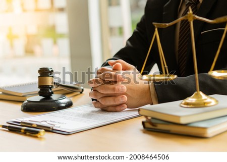 Judge's hammer and brass scales on a wooden table in the office with lawyers and legal services, advice, justice.