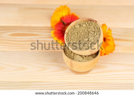 Dry henna powder in bowls on wooden table