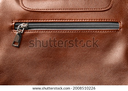 Zipped pocket on brown leatherette background Royalty-Free Stock Photo #2008510226