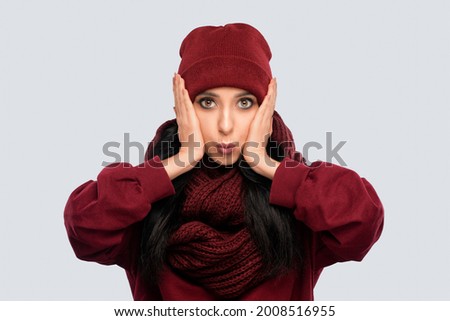 Cheerful and emotional  brunette girl with beautiful makeup, with clean skin, long hair in a burgundy  winter sweater and in a hat . New Year concept