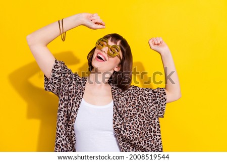 Photo of funny young lady dance wear eyewear bracelet leopard shirt isolated on yellow color background