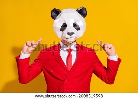 Photo of promoter freak guy indicate finger head wear panda mask red suit isolated on yellow color background