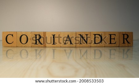 The word Coriander was created from wooden letter cubes. Gastronomy and spices. close up.