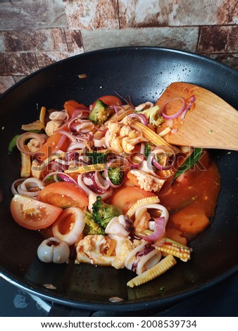 The picture shows a Malay dish that is squid paprika mixed with vegetables in a pan