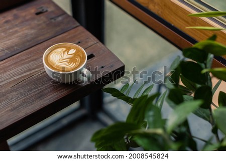 coffee latte on wood bar with coffee shop background Royalty-Free Stock Photo #2008545824