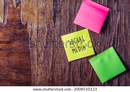 Colorful sticky notes on wooden background board reminder with copyspace. Social media written sticker on pineboard. Digital marketing and social media business concept.