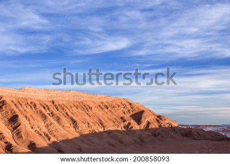 A nice rocky mountain with a beautiful blue sky mixed with clouds during sunset