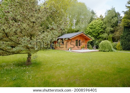  flowers in front of a wooden hut. Garden joy in summer. Relax in the garden and enjoy the beautiful weather. Lavender and hydrangea in pot next to a garden shed  Royalty-Free Stock Photo #2008596401
