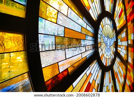 Decorative church stained glass window with dove