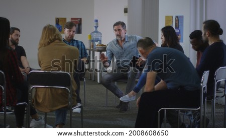 Mature counselor speaking with group during meeting Royalty-Free Stock Photo #2008608650