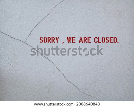 red sign on cracked cement wall written SORRY, WE ARE CLOSED , to inform customers or visitors the place is not on service hours or closed down