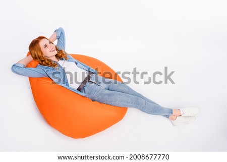 Full length photo of relaxed happy nice young woman hold hands behind head sit chair isolated on grey color background