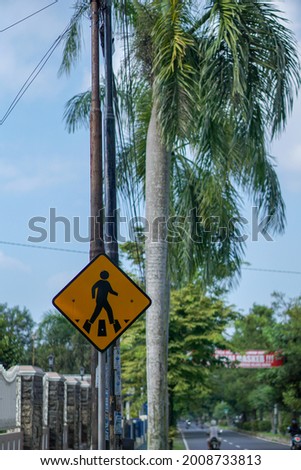 people crossing traffic sign, icon of people crossing the road, yellow, being on the side of the road