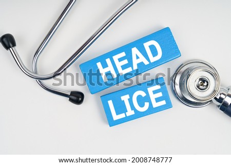Medicine and health concept. On the table is a stethoscope and blue Jenga with the inscription - Head lice